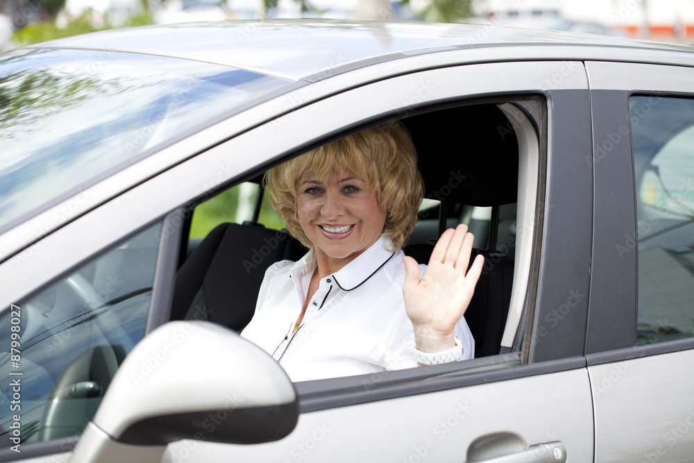 Old happy elderly driver woman 55-60 years in jacket Driving a C Old happy elderly driver woman 55-60 years in jacket Driving a C