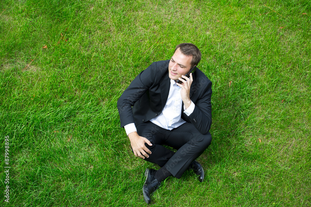 Cheerful young businessman calling by phone Cheerful young businessman calling by phone