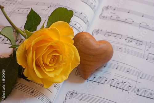 Gelbe Rose und Herz auf einem Notenblatt