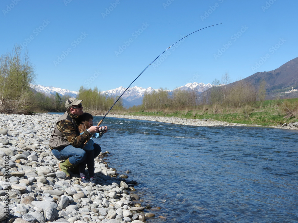 Cheerful father and daughter fishing together on the river Cheerful father and daughter fishing together on the river