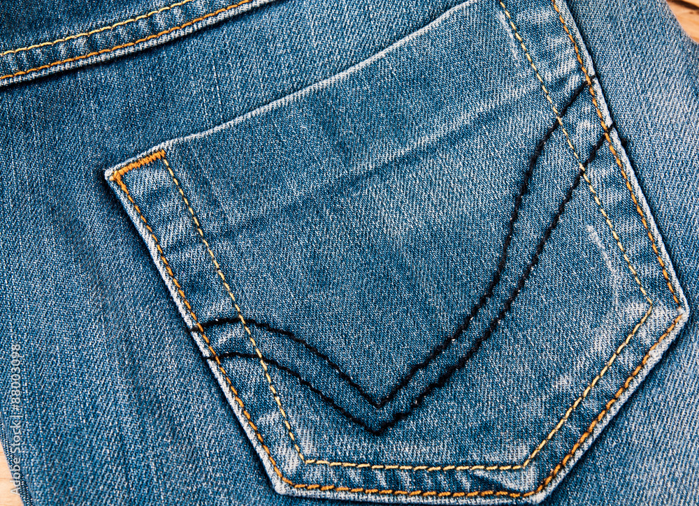 fashionable clothes. pile of jeans on a wooden background fashionable clothes. pile of jeans on a wooden background