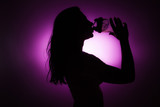 Silhouette of girl drinking a shake.