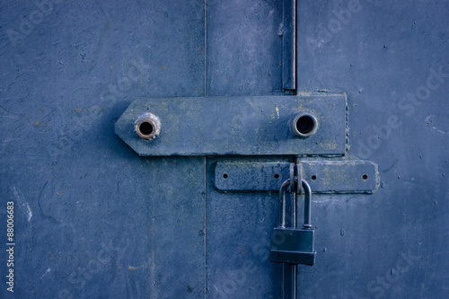 black metal padlock on grey metal garage gates © rainbow_ray