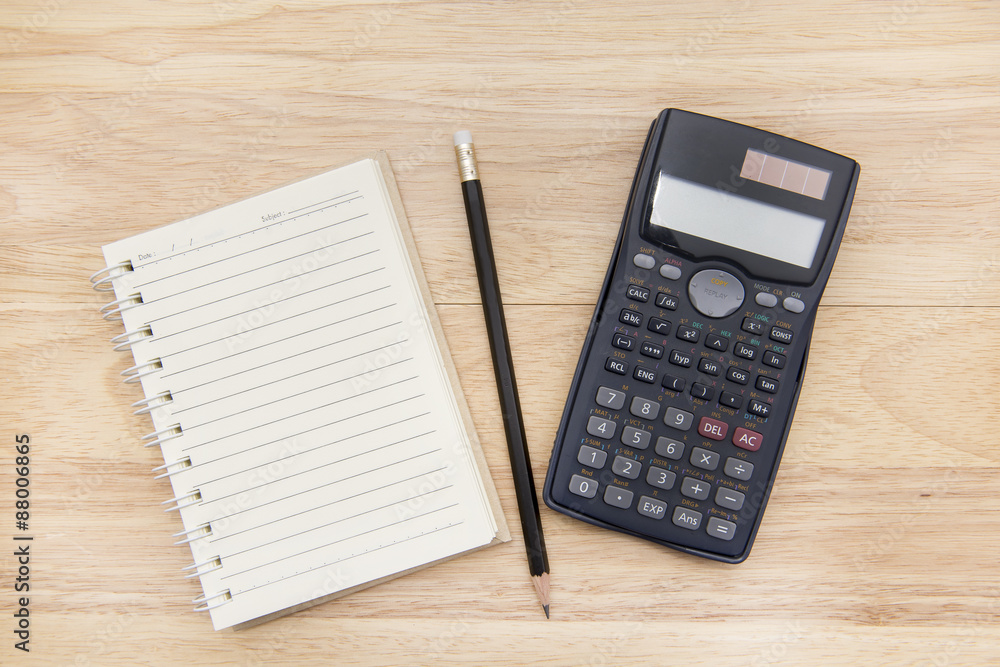 calculator, note and pencil on wood background calculator, note and pencil on wood background