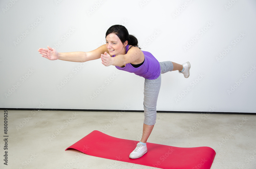 Fototapeta premium junge frau trainiert ihre balance mit yoga