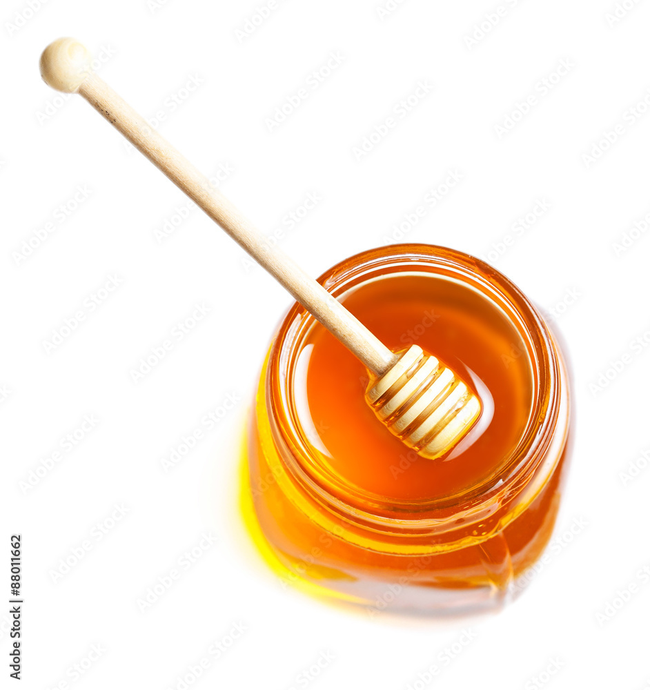 Honey Dipping with honey in glass jar isolated on white backgrou Honey Dipping with honey in glass jar isolated on white backgrou