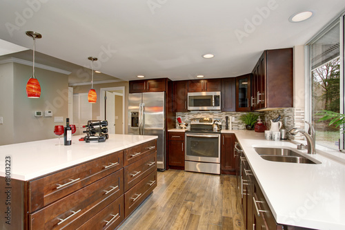 Large kitchen with white counter tops.