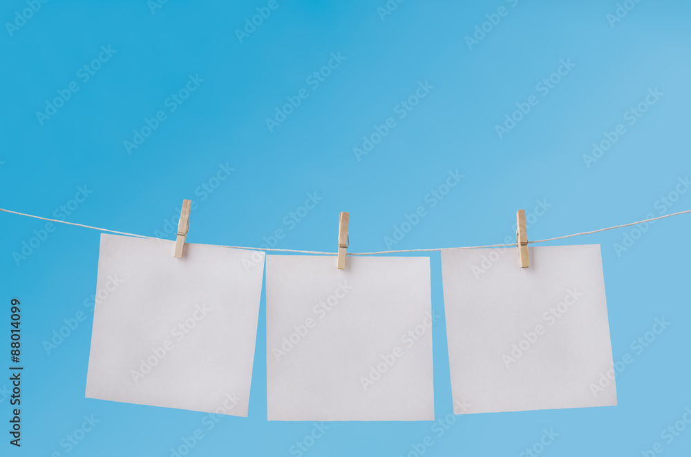 Three Blank Notes Pegged on Washing Line against Blue Sky Three Blank Notes Pegged on Washing Line against Blue Sky