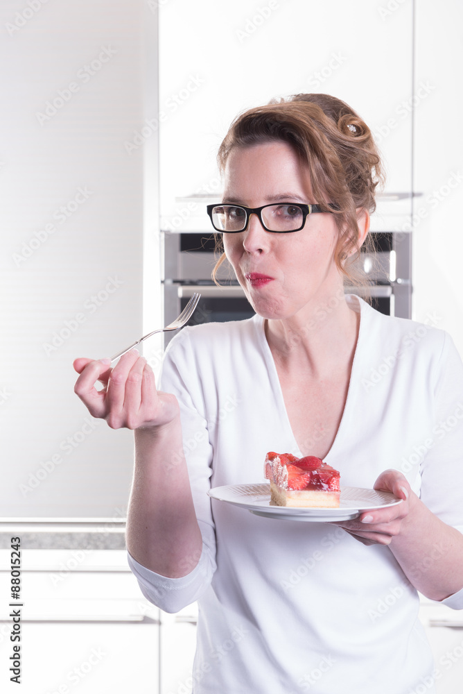 © Jürgen Hüls - attractive woman in modern ktchen eating strawberry cake
