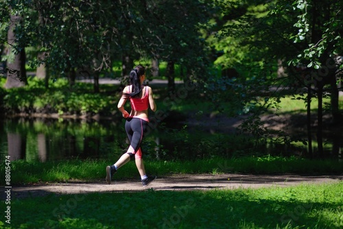 Beautiful woman runner running in city park © dojo666