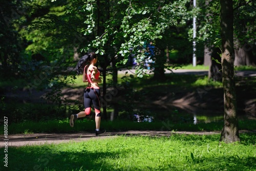 Beautiful woman runner running in city park