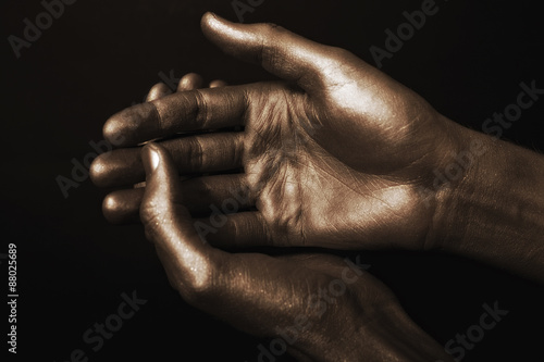 beautiful man's hands in golden paint on black background
