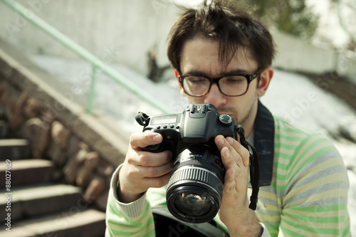 young man in spectacles with camera