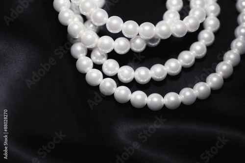 white pearl necklace on a black silk close up