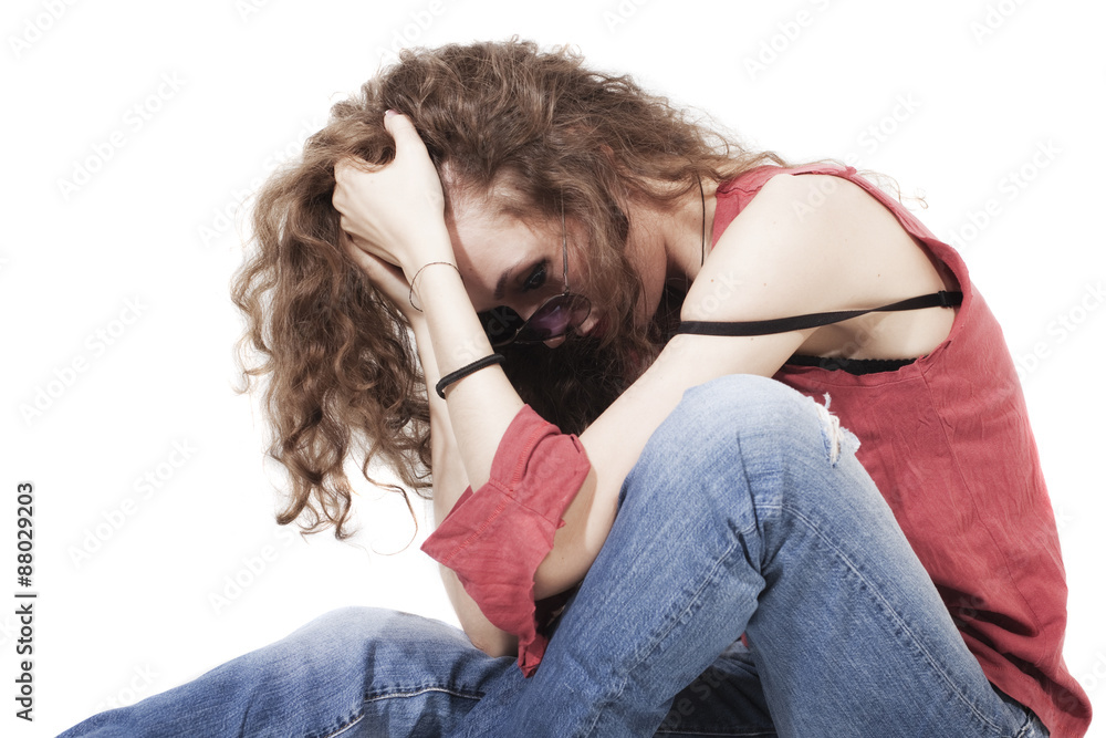 Obraz premium curly brunette woman in red T-shirt and blue jeans