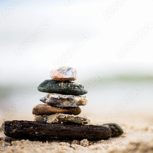 Stones pyramid on sand. Sea in the background