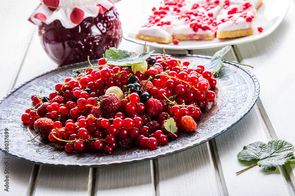 Red currant sponge cake. Plate with Assorted summer berries, raspberries, strawberries, cherries, currants, gooseberries Red currant sponge cake. Plate with Assorted summer berries, raspberries, strawberries, cherries, currants, gooseberries