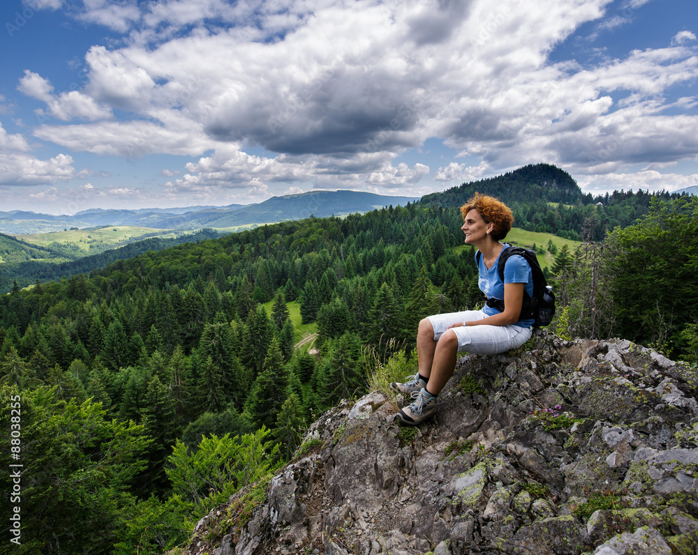 Woman sitting on a mountain peak