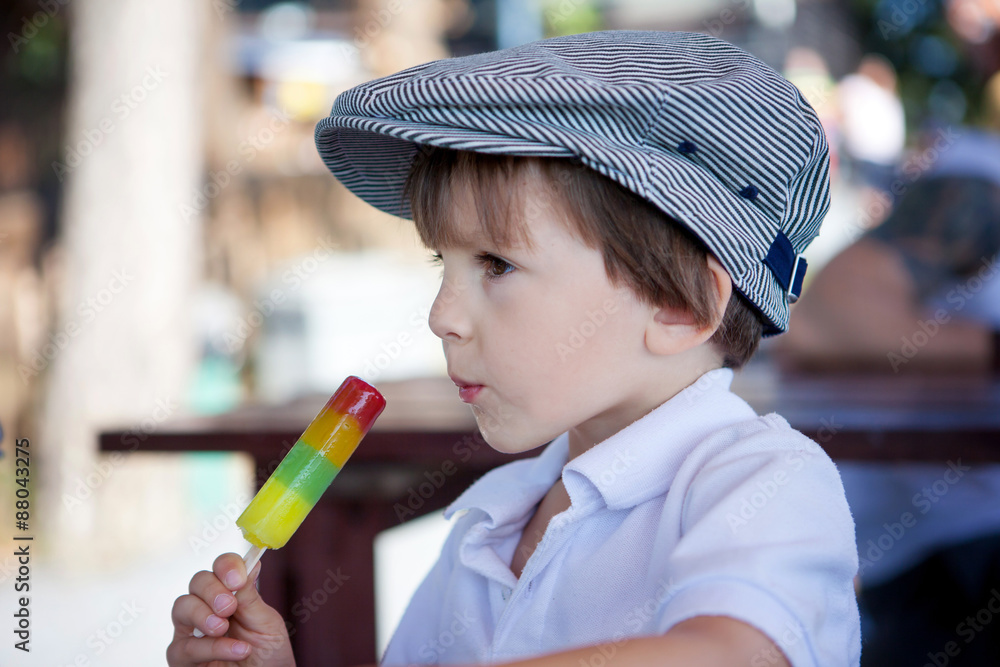 Cute sweet boy, child, eating colorful ice cream in the park Cute sweet boy, child, eating colorful ice cream in the park