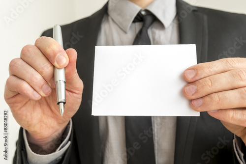 Businessman Holding Pen and Empty White Paper