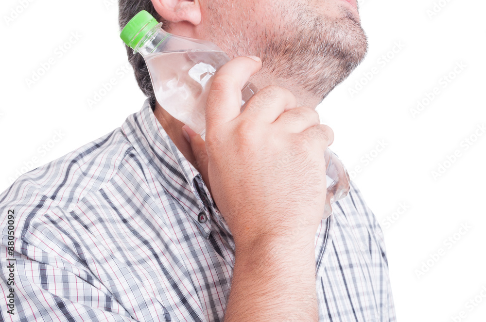 Man cooling his neck with a bottle of cold water Man cooling his neck with a bottle of cold water