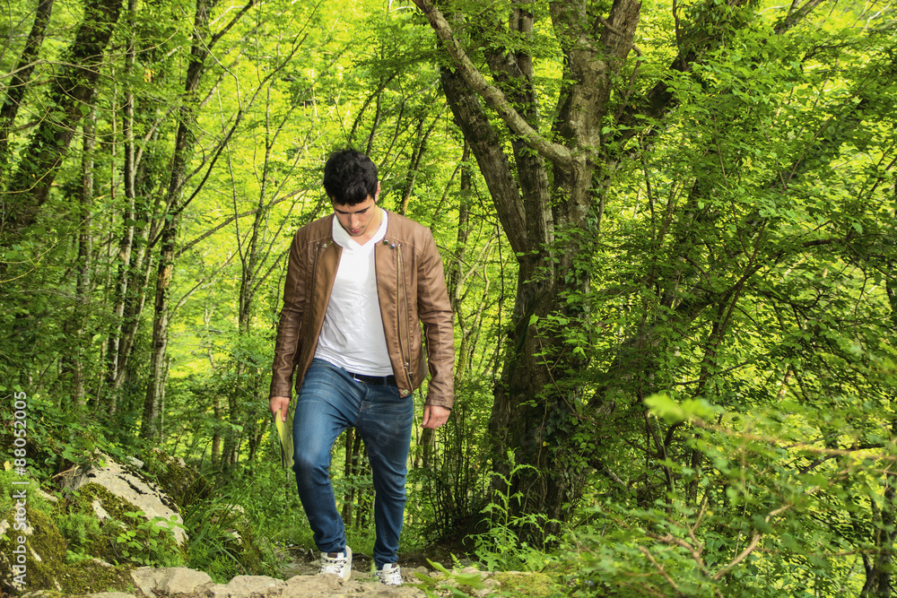 Young man hiking in lush green mountain scenery Young man hiking in lush green mountain scenery