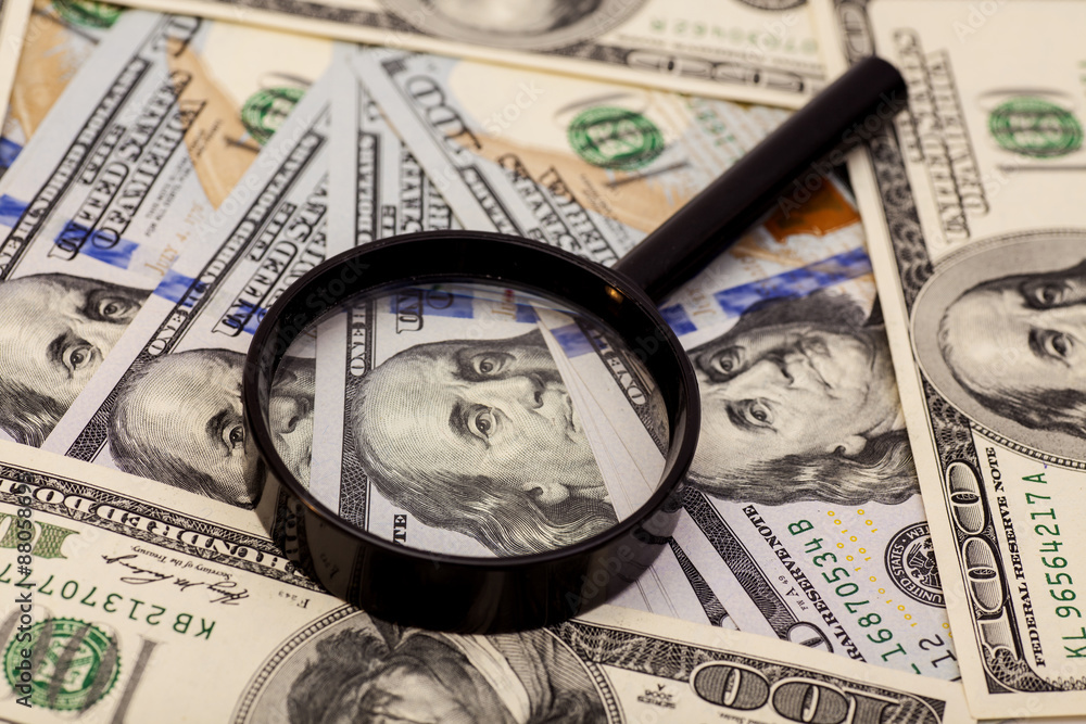 Hundred dollar banknote under magnifying glass Hundred dollar banknote under magnifying glass
