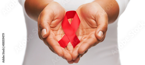 hands holding red AIDS awareness ribbon photo