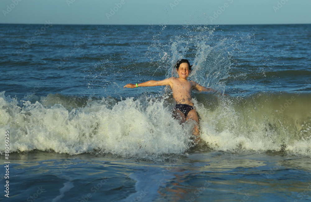 child plunges over the waves of the choppy sea in summer child plunges over the waves of the choppy sea in summer