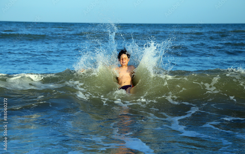 brave child plunges over the waves of the choppy sea