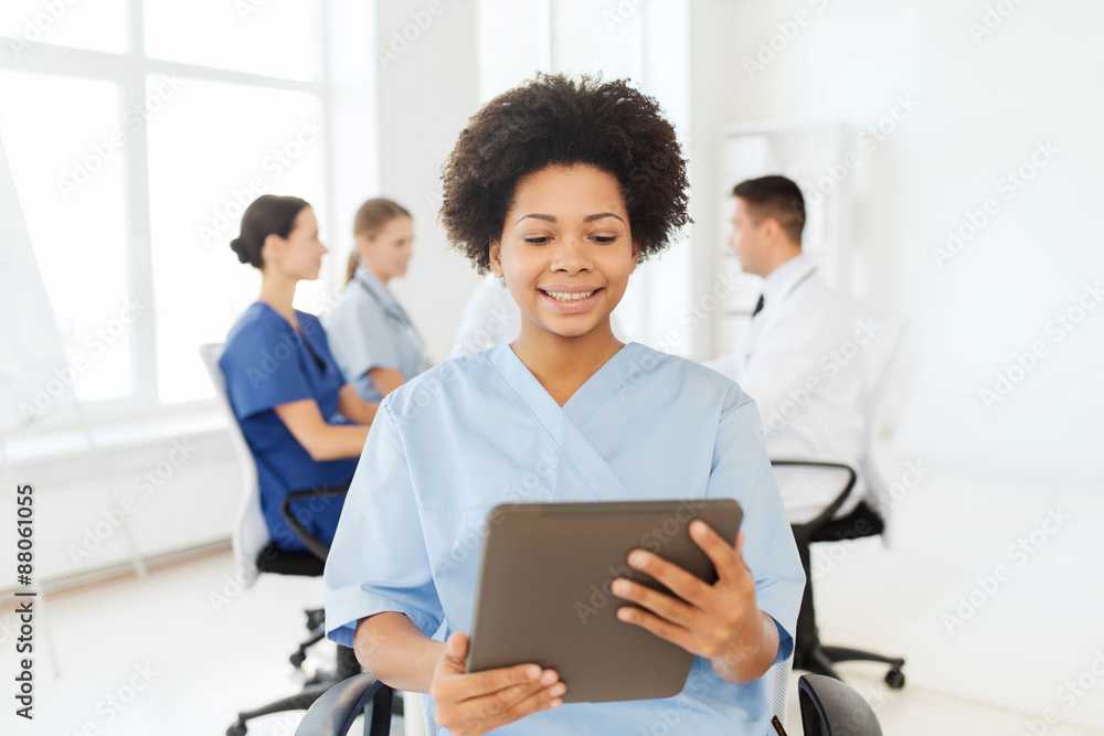 happy nurse with tablet pc over team at hospital happy nurse with tablet pc over team at hospital