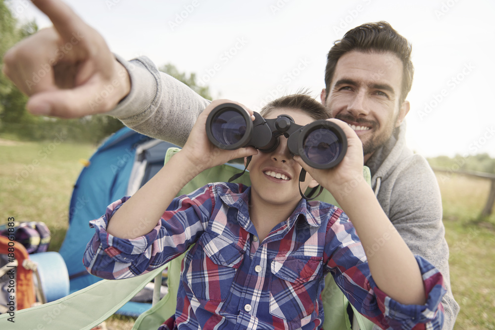 Father showing son the world via binoculars