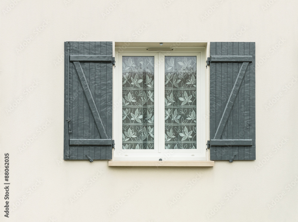 Fototapeta premium Weißes PVC Fenster mit Belüftung und Holzklappladen 