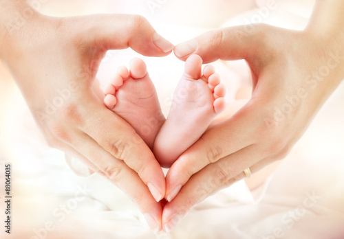 Fotografiet baby feet in mother hands - hearth shape