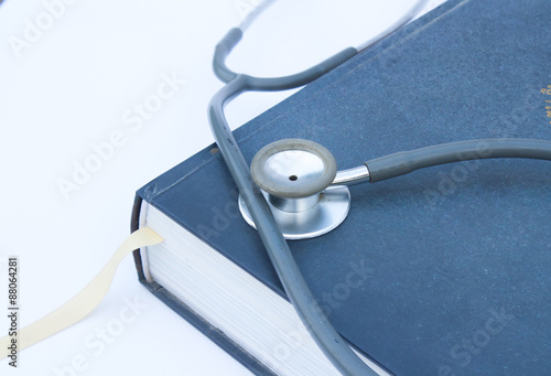Stethoscope old put on a thick hardcover book.