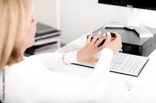 Frau lackiert sich die N  gel am Schreibtisch
