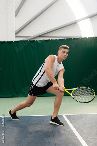 young man play tennis outdoor on orange court 