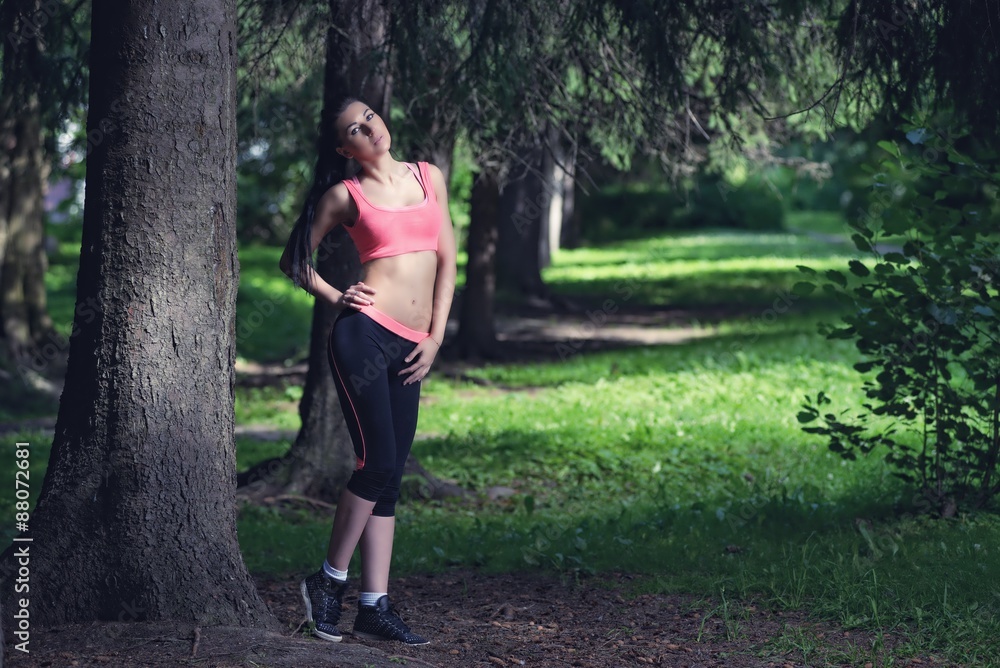 Portrait of fashion fitness model posing in park