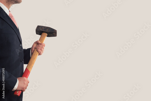 Фотография Businessman holding a sledgehammer in his hands