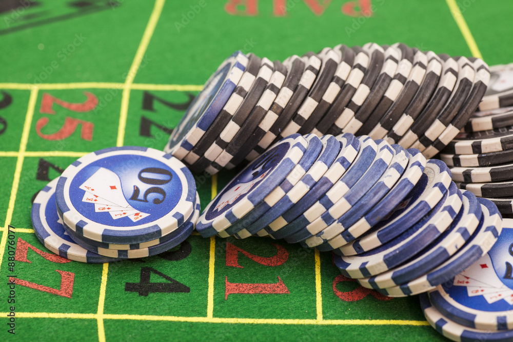 casino chips on green felt game table in a casino casino chips on green felt game table in a casino