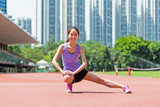 Woman doing stretches exercise in sport arena