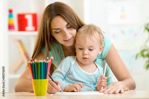 Mother and toddler child draw and paint together