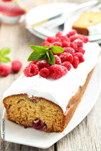 Raspberry cake on plate on grey wooden background
