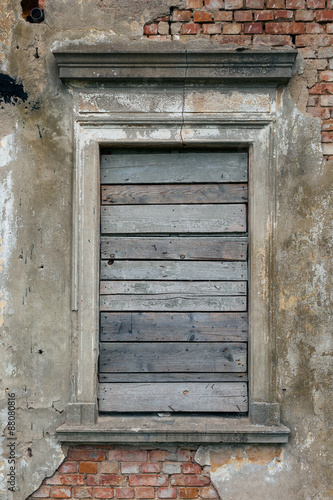 Old  boarded up window in the ruined wall of an old manor house in Poland.