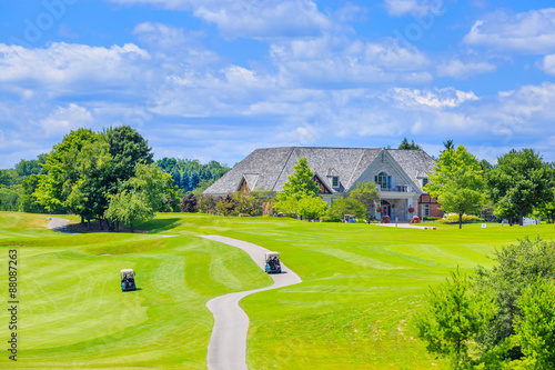 Golf place and custom built luxury big house on background.