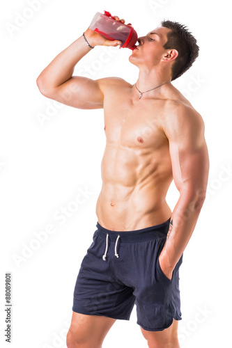 Muscular young man holding protein shake bottle © theartofphoto