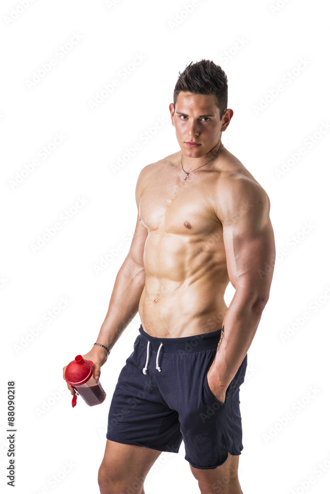 Muscular young man holding protein shake bottle Muscular young man holding protein shake bottle