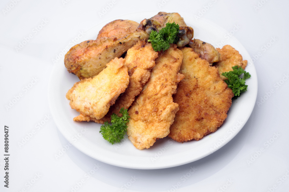 Breaded pork chops and chicken legs on plate Breaded pork chops and chicken legs on plate