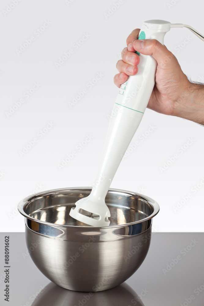 Holding a hand mixer in a bowl Holding a hand mixer in a bowl