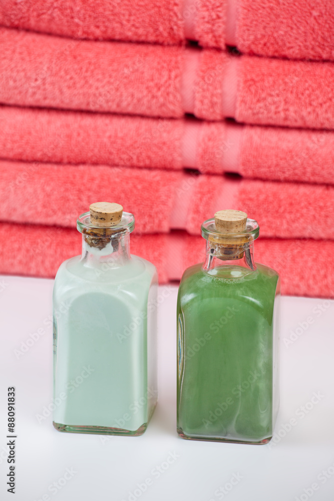 Two lotion bottles in front of towels Two lotion bottles in front of towels
